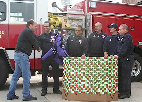 Arlington Heights firefighters receive a coat donation for their Coat Drive