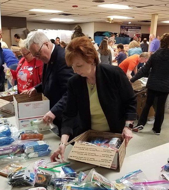 State Rep. Mark Walker (left) packs care packages with state Sen. Gillespie (right) and other volunteers at Help USA Troops