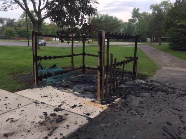 Fire-damaged portable toilet, enclosure and tree at Hasbrook Park on Maude Avenue