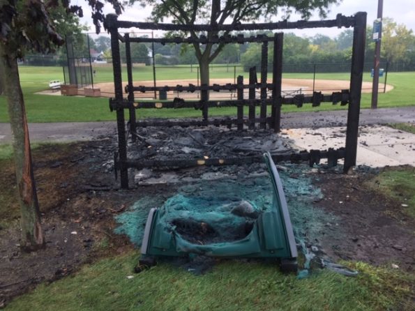 Fire-damaged portable toilet, enclosure and tree at Hasbrook Park on Maude Avenue