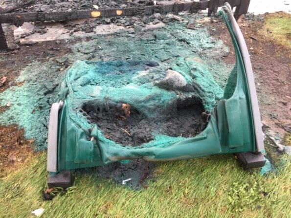 Fire-damaged portable toilet, enclosure and tree at Hasbrook Park on Maude Avenue