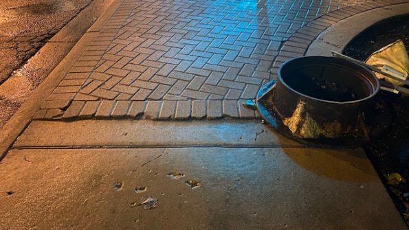 Cracked bricks and manhole piece at edge of corner at Northwest Highway and Arlington Heights Road