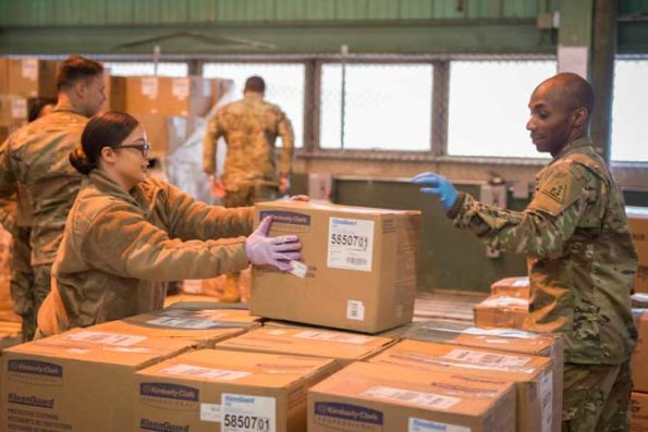 Connecticut National Guardsmen organize boxes containing personal protective equipment at a warehouse in New Britain, Conn., March 30, 2020