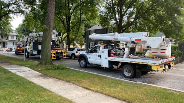 Three of at least six ComEd trucks part of preparation to install two new utility poles and restore power lines