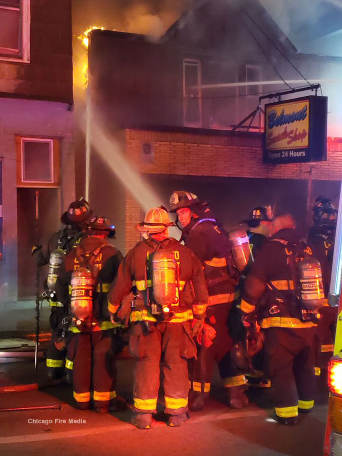 Belmont Snack Shop fire with with firefighters working to prevent the fire from spreading to the building to the left (Chicago Fire Media)