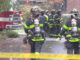 Firefighters with axes standing by t the scene of a gas main leak in Arlington Heights, Illinois