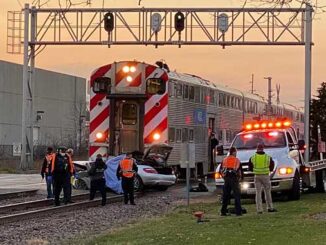 Preparing to tow silver Mercedes sedan off of railroad tracks at Ridge Avenue and Northwest Highway in Arlington Heights