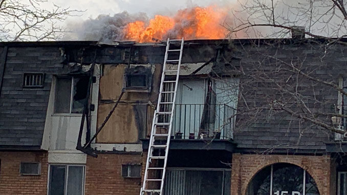 Significant fire showing from the roof after it burned off a section of vertical mansard roof at condo apartment fire in Palatine (PHOTO CREDIT: Lance Neuses)