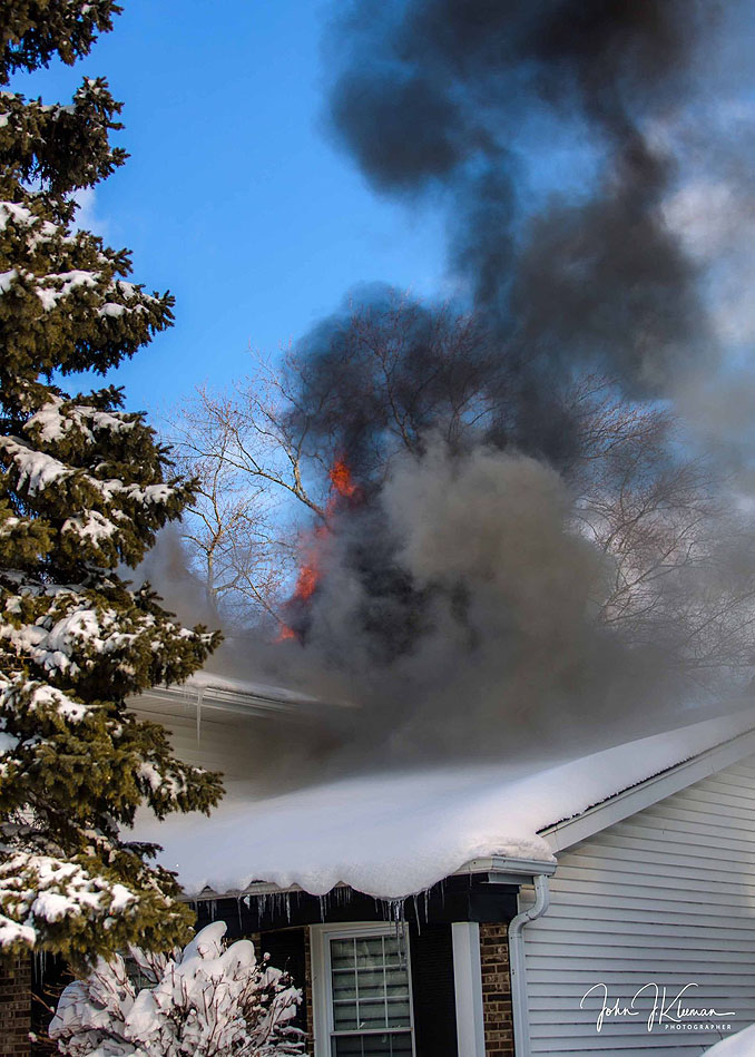 Smoke and flames showing from the back of a house at a house fire on Patton Drive in Buffalo Grove (PHOTO CREDIT: J Kleeman)