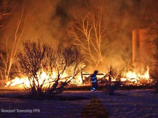 Firefighter walks across property in front of burning barn on Kazmer Road in Newport Township (SOURCE: Newport Township Fire Protection District)
