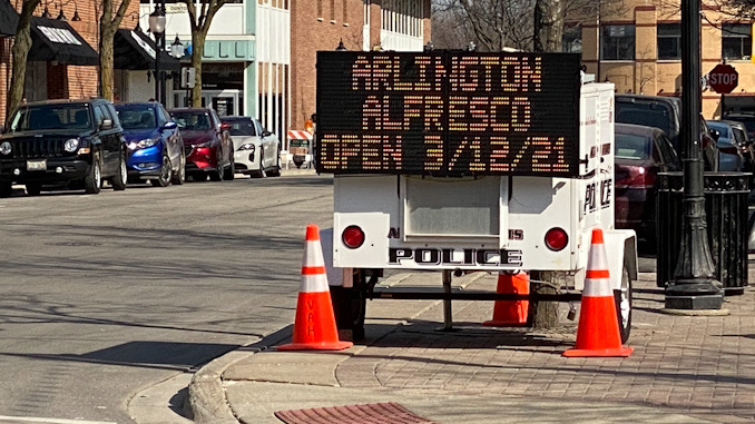 Portable electronic sign board announces Arlington Alfresco opens March 12, 2021.