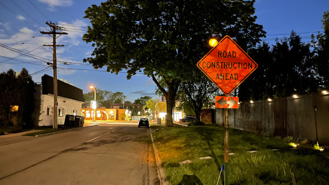 Cross traffic warning sign for ROAD CONSTRUCTION AHEAD on westbound George Street east of Arlington Heights Road in Arlington Heights, May 11, 2021