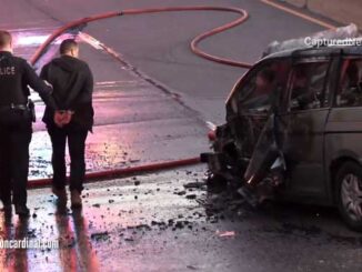 Wrong way driver is led in handcuffs past the destroyed and burned up minivan he was allegedly driving the westbound in the eastbound lanes of Palatine Road Saturday, May 1, 2021