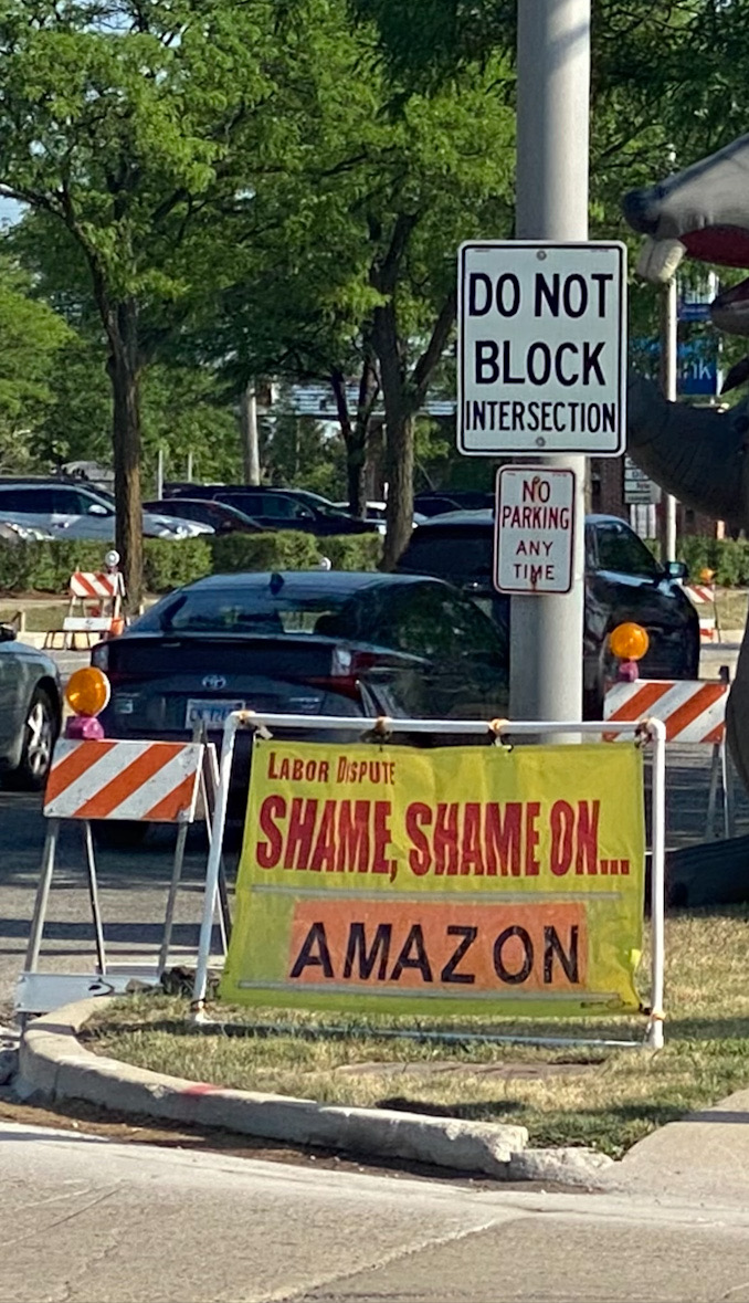 Banner says, "Labor Dispute: Shame, Shame on ... Amazon" at Arlington Heights Road and Lillian Avenue in Arlington Heights