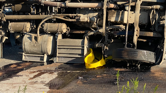 Rollover semi-trailer dump truck with a portable spill containment pool in place.