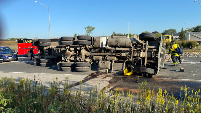 Rollover semi-trailer dump truck with a portable spill containment pool in place.