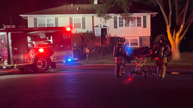 Paramedics stand by immediately after firefighters extinguished a fire at a house on Highland Grove Lane in Palatine