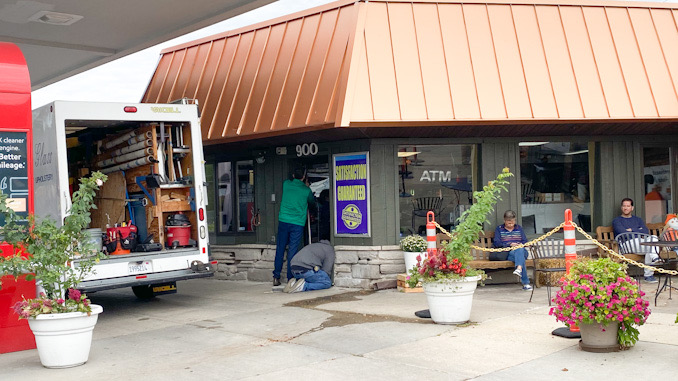 Workers from Suburban Trim & Glass repairing glass door at Northwest Auto Wash after the business was vandalized about 2:40 a.m. Thursday, September 23, 2021