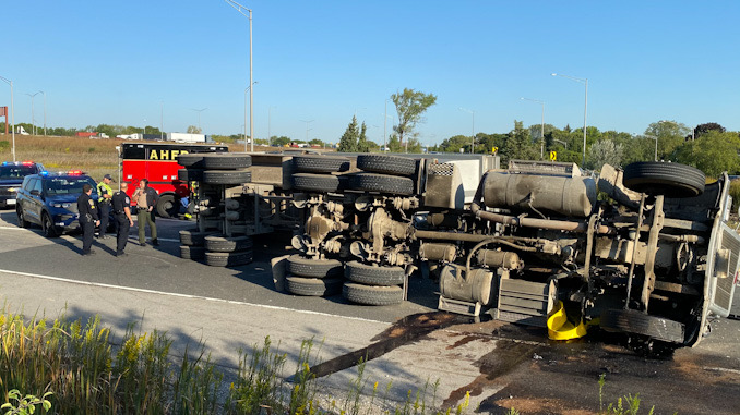 Rollover semi-trailer dump truck with a portable spill containment pool in place