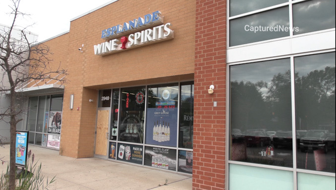 Front glass door boarded up at Esplanade Wine & Spirits on West Euclid Avenue near Salt Creek Lane in Arlington Heights