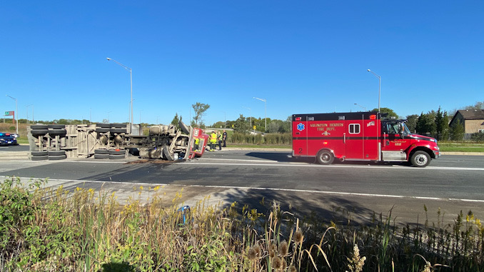 Paramedics assessing the truck driver after a rollover crash at Route 53 and Palatine Road in Arlington Heights