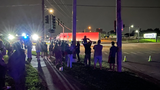 A large crowd gathered as police prepared for a crash investigation at Dempster Street and Linneman Road.