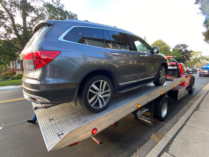 Honda Pilot on a Hillside Towing flatbed tow -- damage was on the driver's side