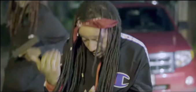 Still frame in rap video showing Darrell Brooks wearing Champion attire