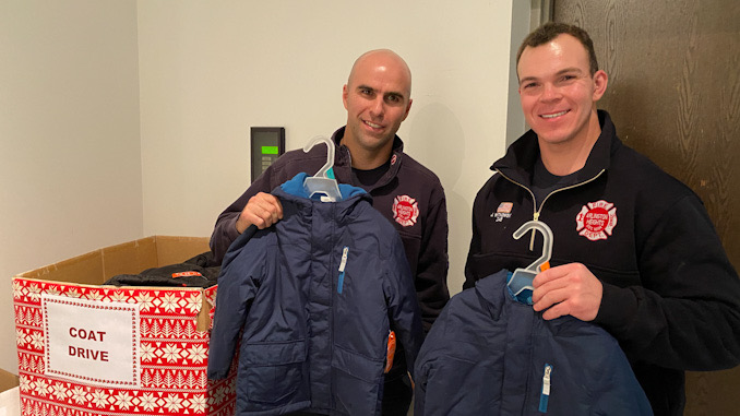 Firefighters at Arlington Heights Fire Station 2 show off some coats already donated to the box at the lobby at Fire Station 2.