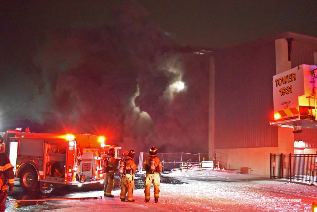 Thick black smoke pours out an overhead door opening at Bay Marine on Wednesday, February 2, 2022 (PHOTO CREDIT: Max Weingardt)