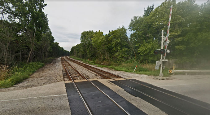 A stolen Toyota sedan driven by armed robbers in an authorized area was struck by a southbound freight train north of this grade crossing at Route 173 (Rosecrans Road) and dragged to the crossing at Route 173 (Image Capture September 2019 ©2022 Google / Street View)