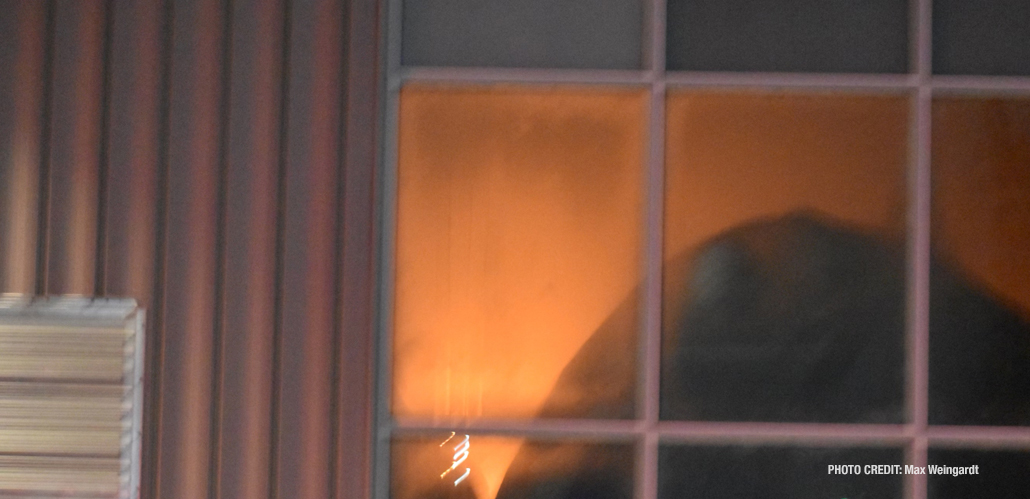 A smoke obscured orange glow visible though a window at Bay Marine, 3 East Madison Street (PHOTO CREDIT: Max Weingardt)