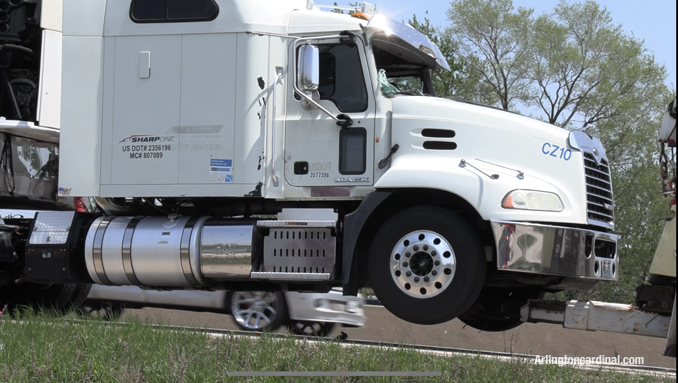 The truck driver in this white semi-trailer truck was injured when a power line came crashing through the windshield of the truck in the southbound lanes after a dump truck's extended dump bed hit power lines that pass over Route 53.