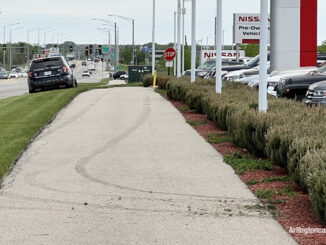 Fresh muddy tire tracks on the sidewalk along the north side of Dundee Road from a stolen vehicle