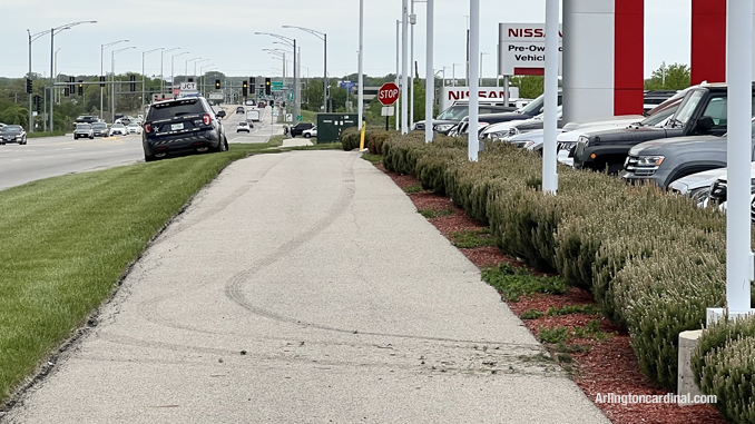 Fresh muddy tire tracks on the sidewalk along the north side of Dundee Road from a stolen vehicle