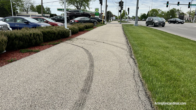 Fresh muddy tire tracks on the sidewalk along the north side of Dundee Road from a stolen vehicle