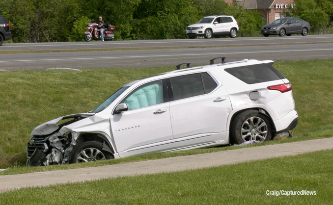 White Chevy Traverse in a ditch with airbag deployment after a crash at Rand Road and Clover Hill Lane in Lake Zurich (PHOTO CREDIT: Craig/Captured New)