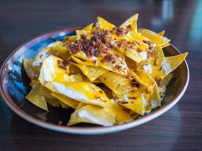 Nachos are a Mexican food consisting of fried tortilla chips or totopos covered with melted cheese or cheese sauce, as well as a variety of other toppings (PHOTO CREDIT: Larry White/pixabay)