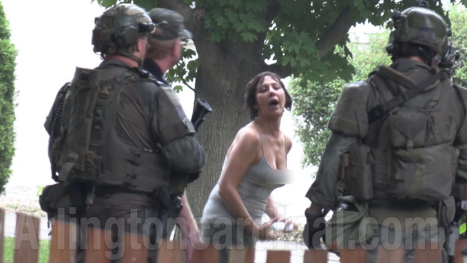 Denise Pesina leans forward while boldly confronting SWAT personnel in front of her home (Arlingtoncardinal.com/CapturedNews)