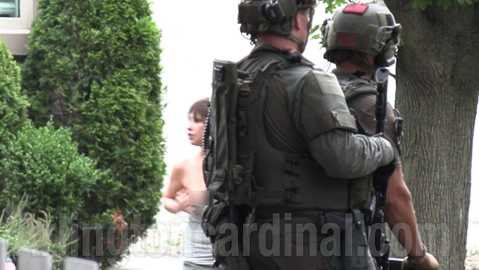 Denise Pesina pulls down her top, exposing her right breast, while confronting NIPAS SWAT personnel waiting to enter her home (VIDEO STILL from Arlingtoncardinal.com/CapturedNews)