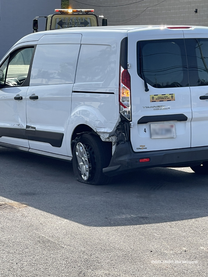 White Ford Transit with minor damage to the left, rear fender (PHOTO CREDIT: Max Weingardt)