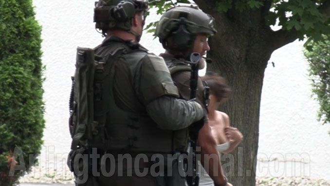 NIPAS SWAT personnel avert, turning and moving their eyes away from Denise Pesina after she exposed her right breast while ranting in the street in front of her home a few hours after her son, mass shooting suspect Robert E. Crimo III, borrowed her Honda Fit (Arlingtoncardinal.com/CapturedNews)