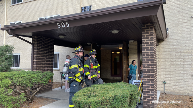 Firefighters wait for additional assignments after completing the initial work of ventilation of a chemical odor at a 3-story residential building