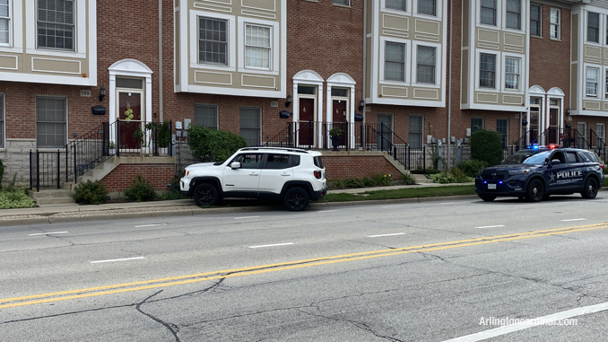 White Jeep Renegade up on the sidewalk on the eastbound side of Sigwalt Street near Arlington Heights Road in Arlington Heights