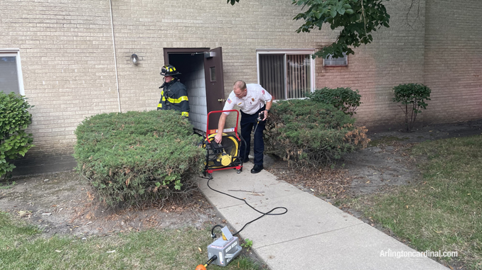 A fan set up at a doorway to ventilate a 3-story residential building affected by a chemical odor related to a floor-finishing product that was applied