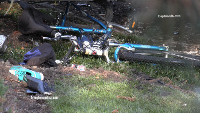A damaged blue Schwinn bicycle and other personal effects of the victim bicyclist on the ground at the southeast corner of Lake Cook Road and Wilke Road in Arlington Heights