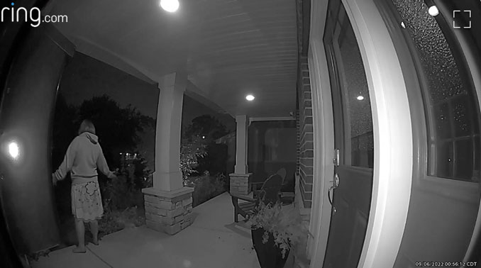 Woman faces outward from a front porch and yells statements toward the front yard (ring camera/neighbors app)