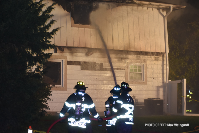 Firefighters attacking the house fire from the exterior, known as defensive (PHOTO CREDIT: Max Weingardt)