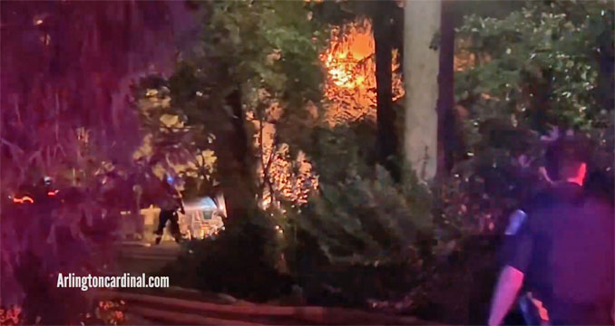 Firefighters with a 2 1/2-inch line stream on a detached garage at the back of a property on Hawthorne Street near Pine Avenue in Arlington Heights, Sunday evening, October 2, 2022