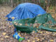 A blue tent serving as a tent in a secluded area of vacant property southeast of Route 53 and Palatine Road in Arlington Heights